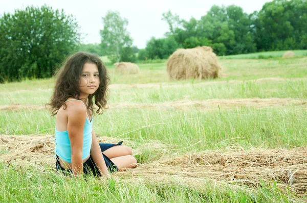Bela menina de cabelos longos em um campo — Fotografia de Stock