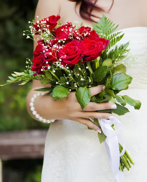 Buquê de casamento com as mãos da noiva rosesat vermelho — Fotografia de Stock