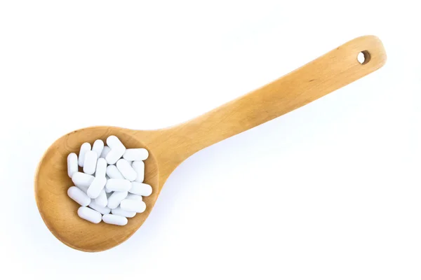 Cucchiaio di legno con pillole — Foto Stock