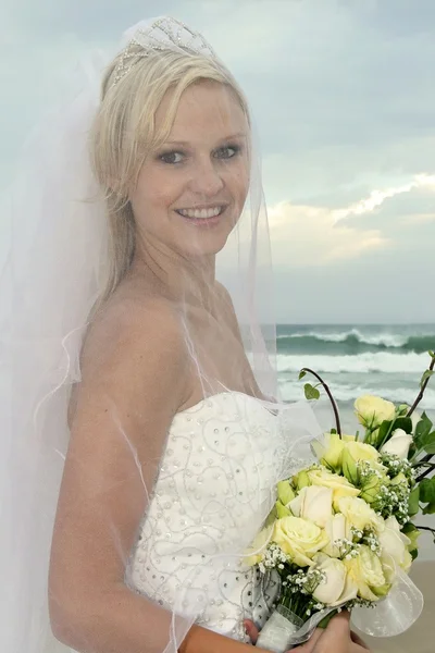 Schöne Braut unter Schleier am Strand — Stockfoto