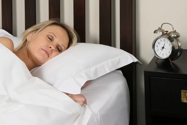 Mooie blonde vrouw in slaap in bed — Stockfoto
