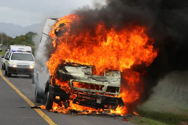 Veículo de entrega em chamas e carros da polícia — Fotografia de Stock