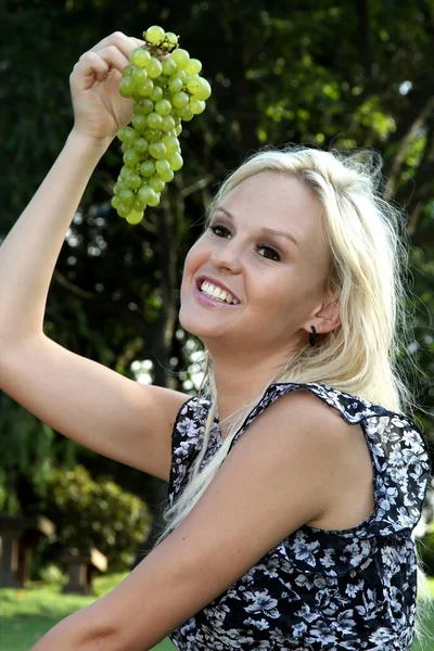 Mooie blonde vrouw en druiven — Stockfoto