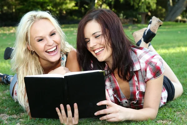 Belle giovani donne amiche leggendo all'aperto — Foto Stock