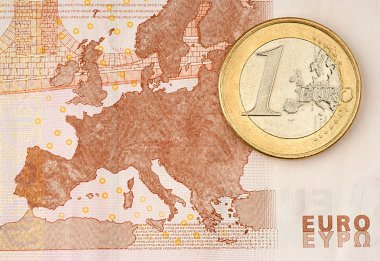 One Euro Coin on Euro Banknote showing Map of Europe clipart