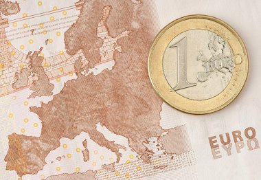 One Euro Coin on Euro Banknote showing Map of Europe clipart