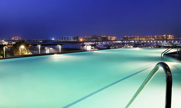 Бассейн и Дубай ночью — стоковое фото