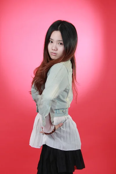 Uma bela garota chinesa isolada no vermelho . — Fotografia de Stock