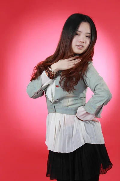 Una hermosa chica china aislada en rojo . — Foto de Stock