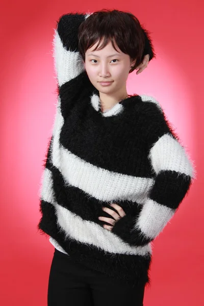 Een mooi Chinees meisje geïsoleerd op rood. — Stockfoto