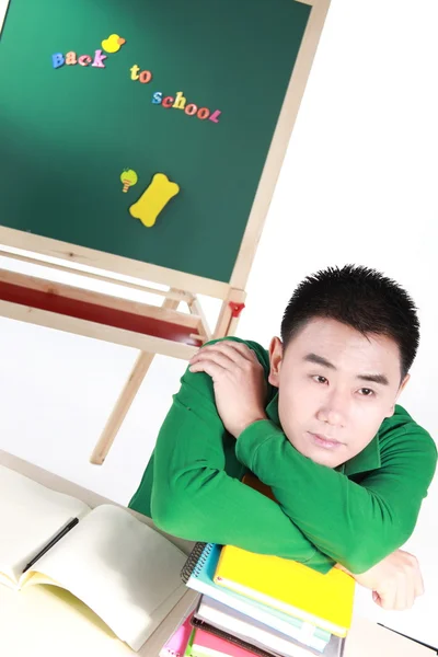 Uczeń ustawienie przy biurku przed tablicą. — Zdjęcie stockowe