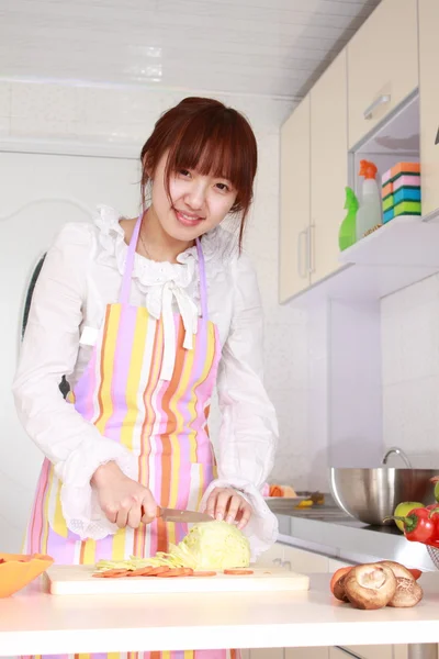Une femme chinoise cuisine différents types de légumes . — Photo