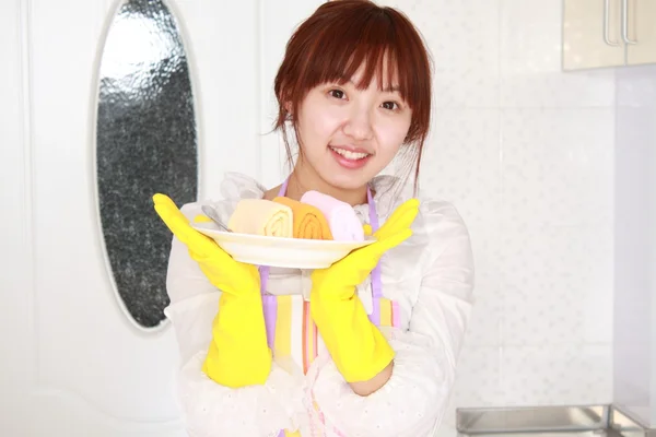 A Chinese woman is cleaning in the kitchen. Stock Image