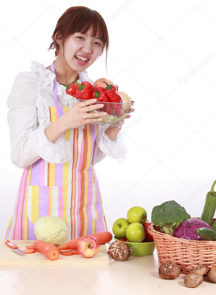 A Chinese woman is cooking various kinds vegetable.