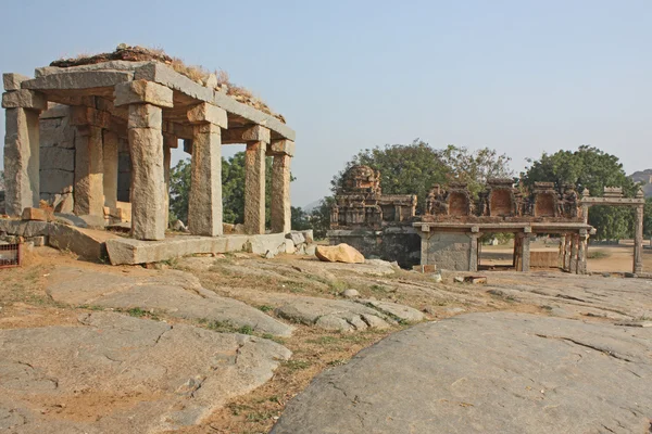 Templo indiano ruína na frente de pedras rochosas maciças — Fotografia de Stock