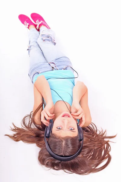 stock image Nice teen girl lying on floor in earphones