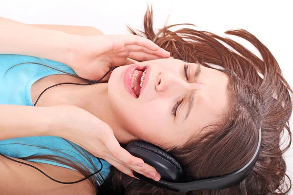 Όμορφο κορίτσι ξαπλωμένο στο πάτωμα σε ακουστικά — Φωτογραφία Αρχείου