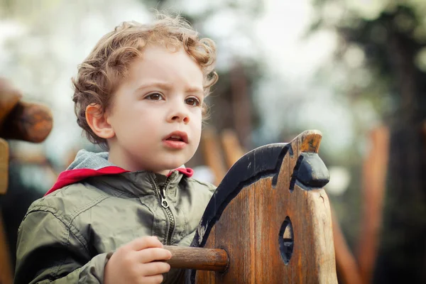 Niño jugando en el parque a caballo — Foto de Stock