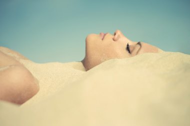 Beautiful lady buried in the sand clipart