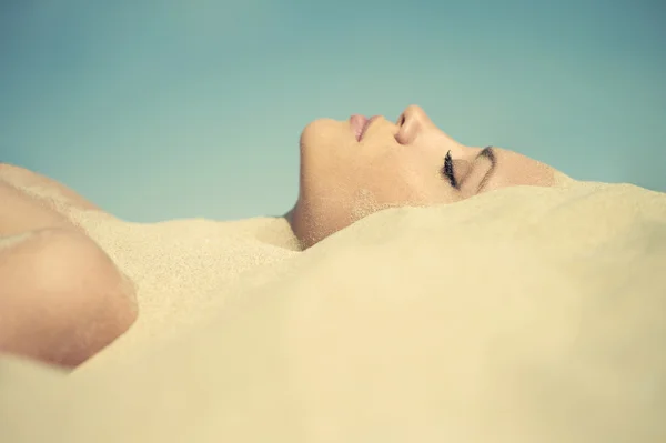 Beautiful lady buried in the sand — Stock Photo, Image