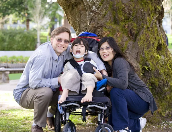 Bambino disabile circondato da genitori — Foto Stock
