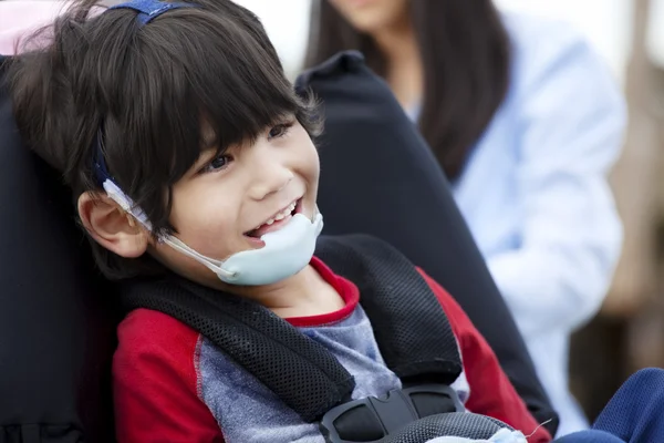 Счастливый пятилетний мальчик-инвалид в инвалидной коляске и защитных очках — стоковое фото