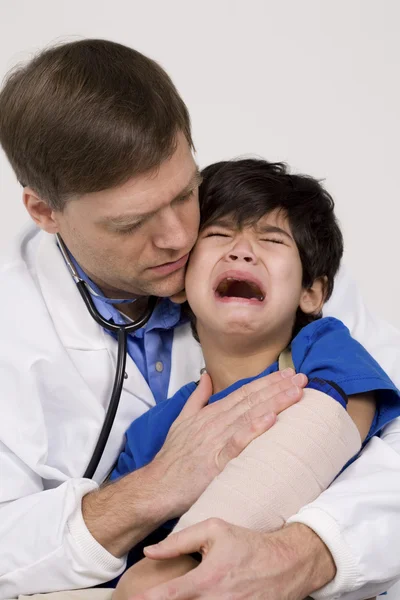 Erkek doktor korkmuş yürümeye başlayan çocuk hasta ve rahatlatıcı. — Stok fotoğraf