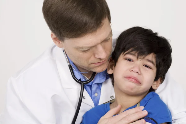 Hombre médico reconfortante asustado niño paciente . —  Fotos de Stock