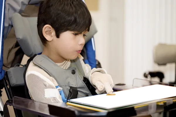 Vijf-jarige gehandicapte jongen studeren in rolstoel — Stockfoto