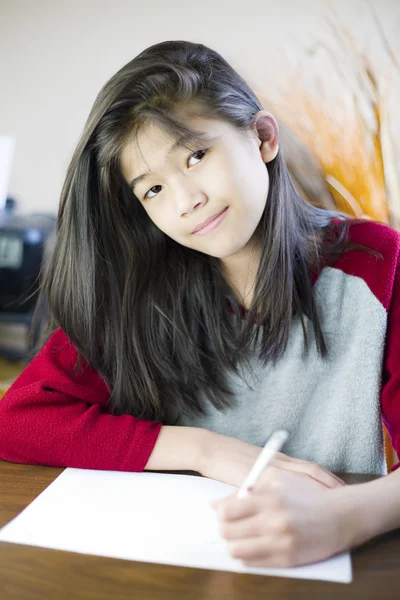Dez anos de idade menina escrevendo ou desenho em papel — Fotografia de Stock