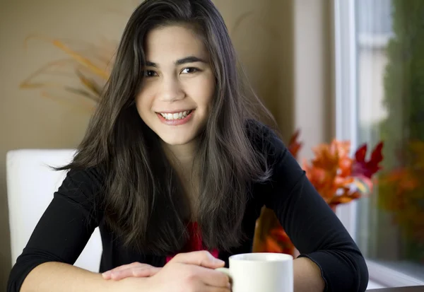 Vacker tonårsflicka vid bord med kaffe mugg — Stockfoto
