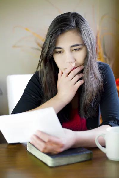 Menina adolescente ou mulher jovem lendo uma nota, expressão preocupada — Fotografia de Stock