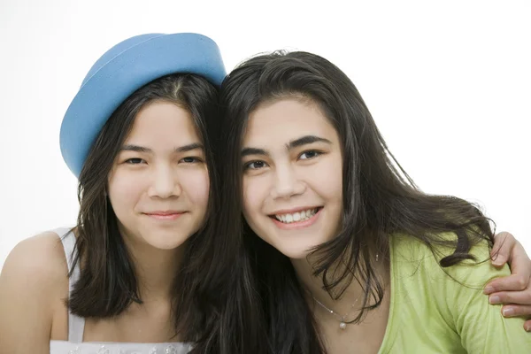 Zwei Teenie-Mädchen lächeln zusammen und umarmen sich. — Stockfoto