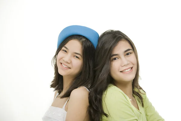 Dwie młode dziewczyny nastolatki na powrót siedzi razem, na tle — Zdjęcie stockowe