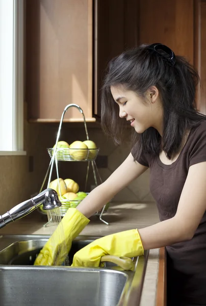 Adolescente chica lavando platos en cocina fregadero —  Fotos de Stock