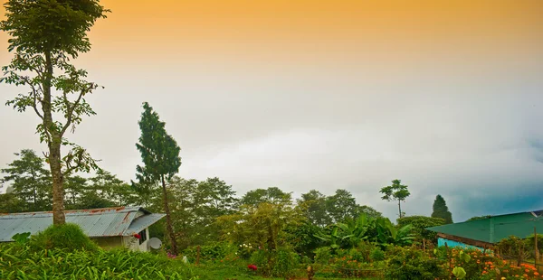 stock image The green valley, village cottage with orange, blue sky and cloud, green hills