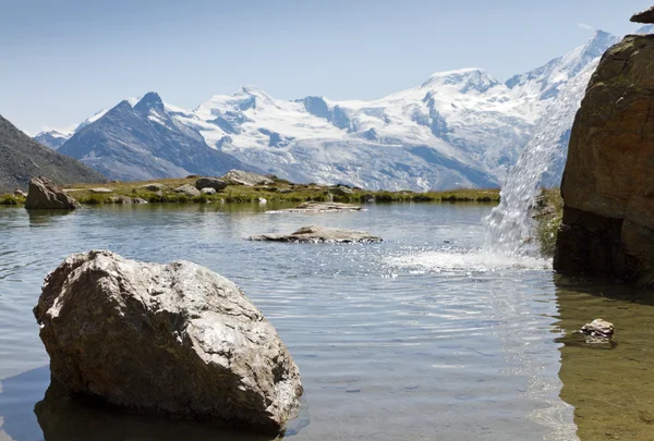 stock image Alpine lake with waterfall