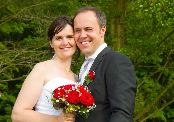 Frisch verheiratetes Paar mit roten Rosen — Stockfoto