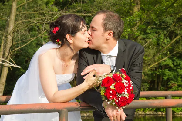 Csók a menyasszony és a vőlegény az esküvő után — Stock Fotó