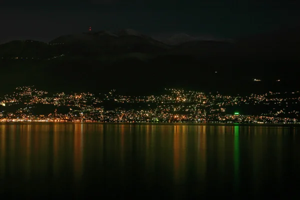 Luces de la ciudad reflejándose en un lago — Foto de Stock