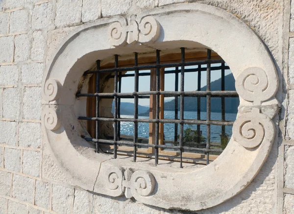 Stone window with a mountainous bay reflecting in it — Stock Photo, Image