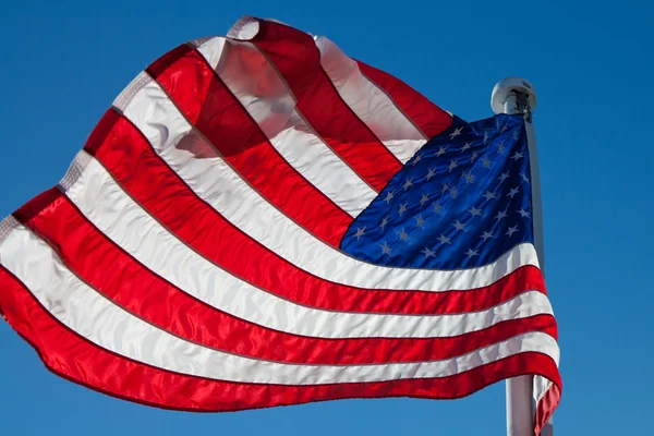 Flying bandera de contraluz estadounidense con copyspace contra un cielo azul — Foto de Stock