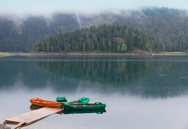 Lago de montanha molhado preto com cais de barco — Fotografia de Stock