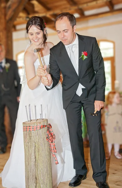 Yeni evliler geleneği takip ve çivi götürmek — Stok fotoğraf