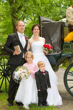 Newlyweds in front of hores carriage clipart