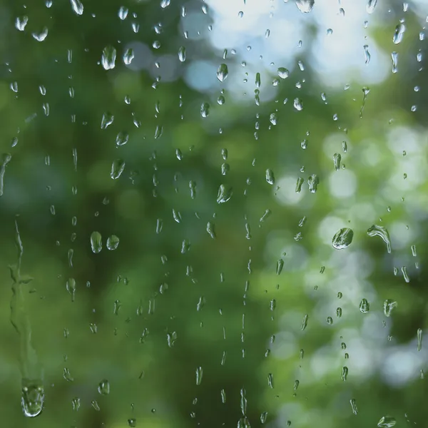 Giornata estiva piovosa, gocce di pioggia sul vetro della finestra, macro primo piano — Foto Stock