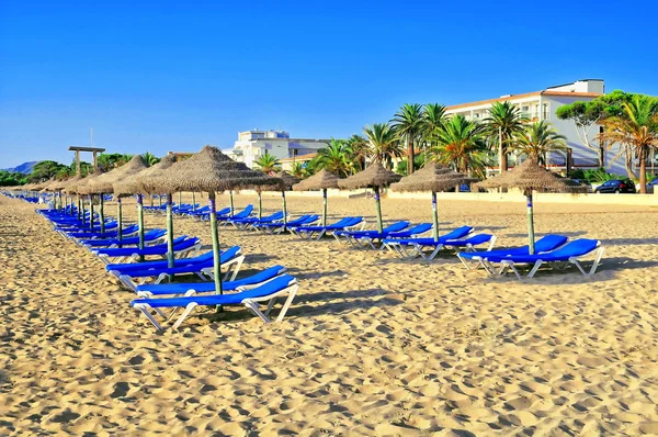 Песчаный пляж с кроватями и зонтиками — стоковое фото