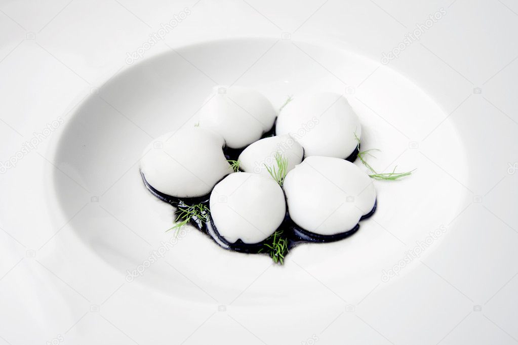 Tiny cuttlefishes served on a white dish