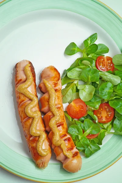 Sausages on the grill with tomatoes and mustard — Stock Photo, Image