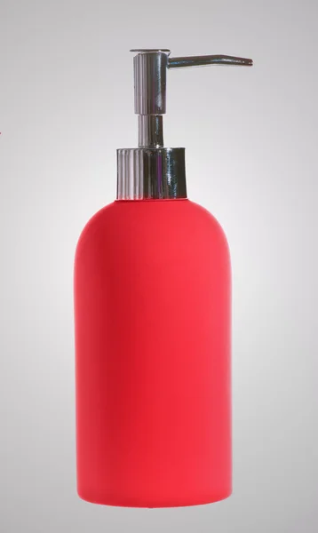 Красная бутылка с мылом — стоковое фото